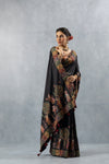 An graceful pose of the model in the Vanya Sarees black folk art saree, highlighting the unique printed border and pallu.