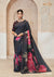 A full-length view of the model in Vanya Sarees' dramatic black organza saree with a large pink and red floral print.