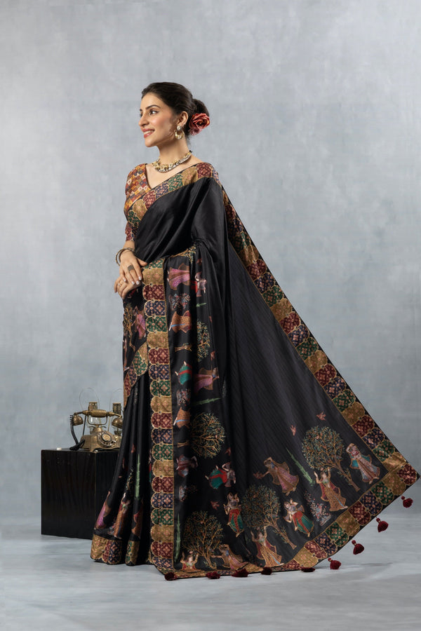 An elegant side profile of the model in the Vanya Sarees black printed silk saree, showcasing the full sweep of the designer pallu.