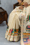 A close-up on the pleats of the Vanya Sarees off-white saree, highlighting the dotted pattern and the vibrant printed border.
