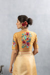 The stunning hand-embroidered back of the designer blouse from Vanya Sarees, featuring a magnificent mural of two lovebirds amidst flowers.