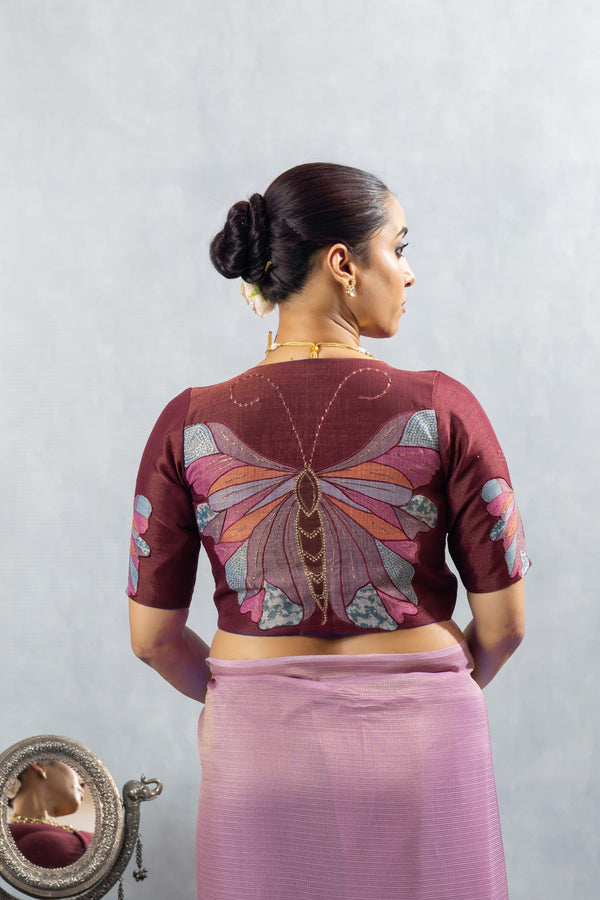 The magnificent handcrafted butterfly appliqué on the back of the maroon designer blouse from Vanya Sarees.