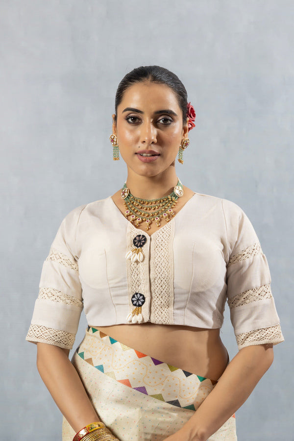 A clear front view of the Vanya Sarees readymade designer blouse in off-white, showing the V-neck and lace details.