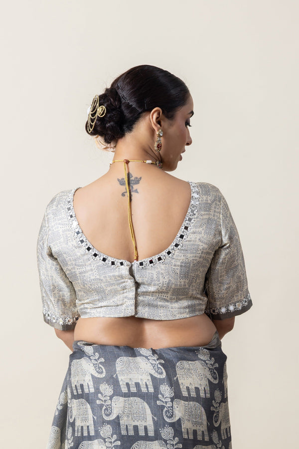 The stylish U-back of the designer blouse from Vanya Sarees, showing the mirror work detail along the neckline.
