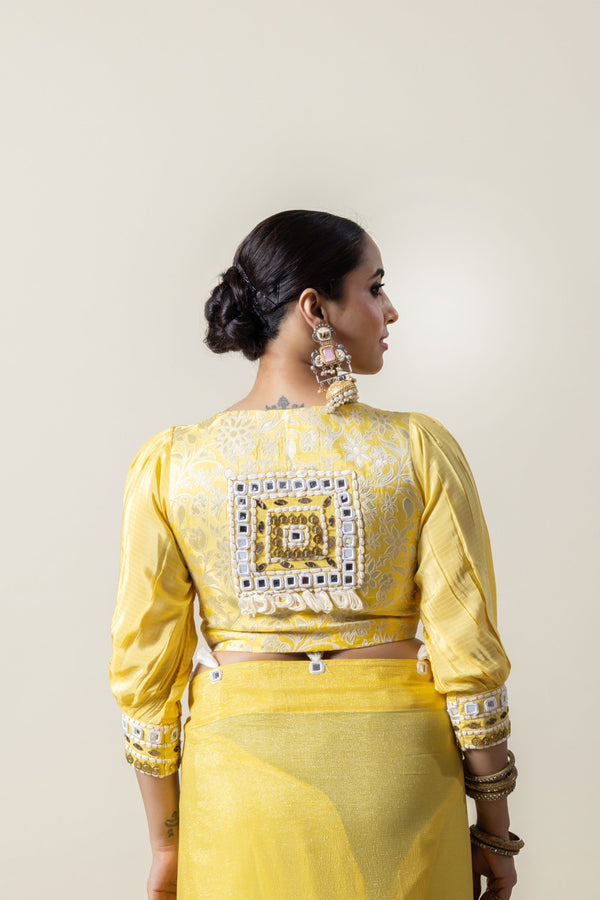 The statement back of the yellow designer blouse from Vanya Sarees, featuring a large Kutch-style mirror work patch.