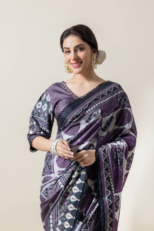 Model smiling warmly in a Vanya purple and grey abstract print designer saree, showing the V-neck blouse detail