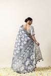 A full back view of the model, displaying the extensive elephant print on the pallu of the Vanya Sarees grey Modal silk saree.