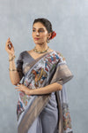 A close-up of the model in a Vanya Sarees grey Chanderi saree, highlighting the artistic print on the shoulder and the rich zari border.