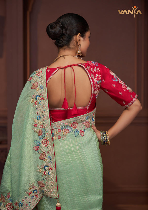 The stunning back view of the Vanya Sarees ensemble, showcasing the heavy embroidery on the pallu and the designer back of the red blouse.