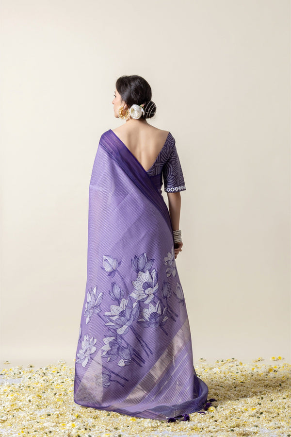 A full back view of the model in the Vanya Sarees ensemble, displaying the lotus print pallu and the dramatic deep V-back of the designer blouse.