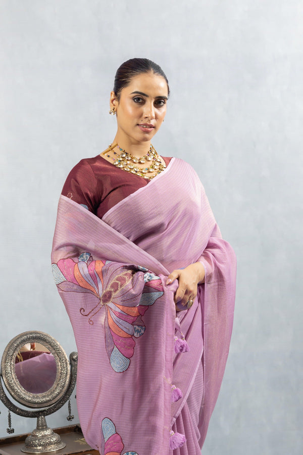 A close-up of the model holding the pallu of the Vanya Sarees lavender saree, showcasing the artistic butterfly print in detail.