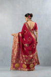 Vanya Maroon Saree back view, highlighting the low scoop neck blouse and the flowing gold zari pallu with large circular motifs.Vanya Maroon Saree back view, highlighting the low scoop neck blouse and the flowing gold zari pallu with large circular motifs.