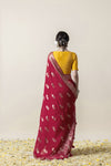 A full back view of the model in the Vanya Sarees ensemble, displaying the woven zari buttis on the pallu and the embellished yellow blouse.