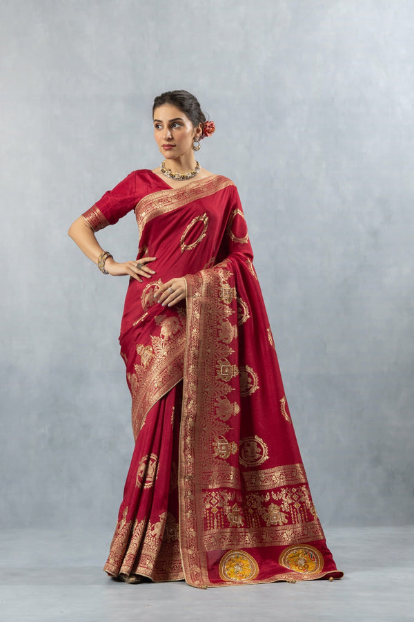 Vanya Maroon Saree side profile pose, showcasing the elegant drape and the heavy gold zari weave on the border and skirt.