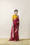 An elegant side profile of the model in the Vanya Sarees maroon woven georgette saree, showing its rich drape and Banarasi border.