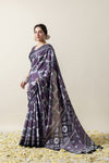 Model in a graceful pose showcasing the fluid fall and extensive print of the Vanya designer purple and grey crepe silk saree.