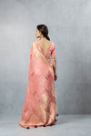 Vanya Peach Saree back view, highlighting the low V-cut blouse and the flowing gold woven pallu.