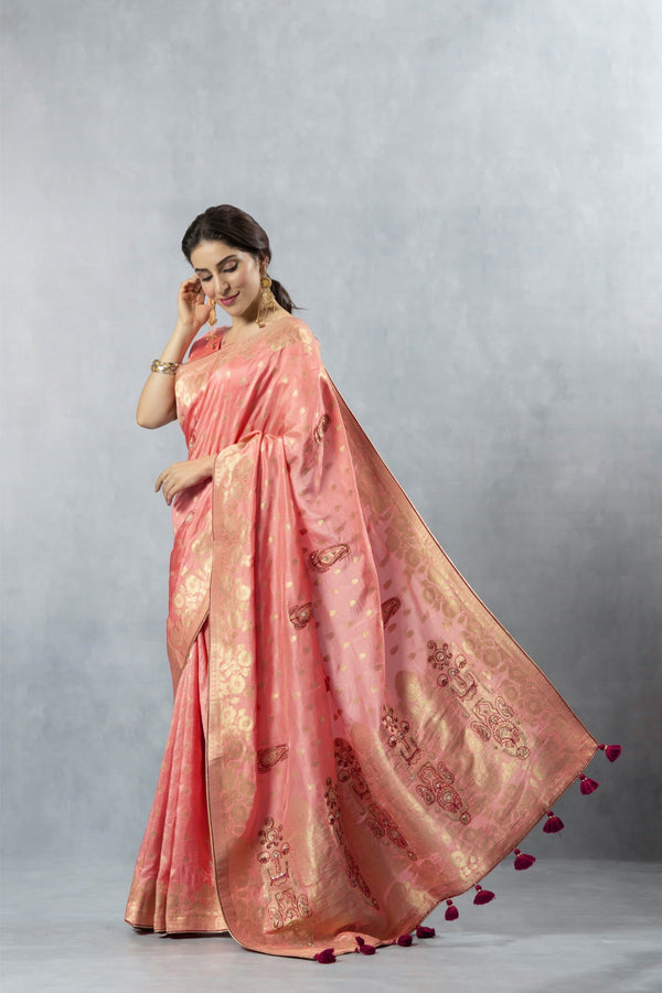 Vanya Peach Saree in a graceful side pose, illustrating the fluidity of the fabric and the full spread of the pallu.