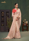 An graceful standing pose of the model showcasing the complete designer look of the Vanya Sarees peach pink Banarasi saree and red blouse.