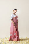 An elegant side profile of the model in the Vanya Sarees pink Leheriya and rose print saree, perfect for a day wedding.