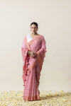 Model in a graceful standing pose in the Vanya Sarees pink Leheriya saree, showing the full drape and rose print pallu.