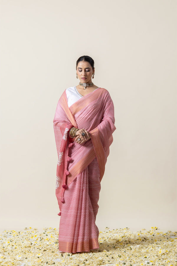 Model in a graceful standing pose in the Vanya Sarees pink Leheriya saree, showing the full drape and rose print pallu.