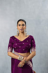 Model wearing Vanya Sarees' deep plum purple satin silk saree, showing the front view of the V-neck designer blouse with elbow-length sleeves.