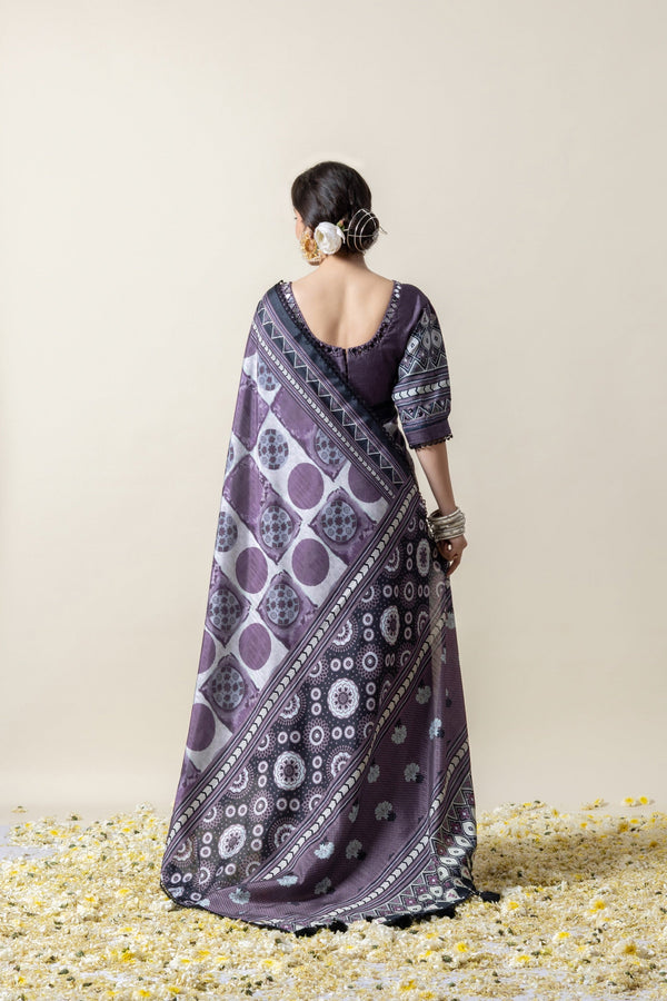 Back view of the model in a Vanya saree, displaying the full printed pattern of the pallu and the elegant hairstyle with a flower.