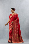 Vanya Red Art Silk saree side pose, showing the fall of the fabric and the geometric weave on the lower skirt.