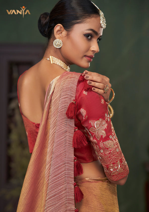 A detailed close-up of the Vanya Sarees designer blouse, showcasing the heavy, handcrafted gold embroidery and tassels on the red sleeve.