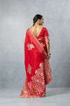 Back view of Vanya Red Saree, featuring the low-cut back of the blouse and the striped, flowing pallu with large motifs.