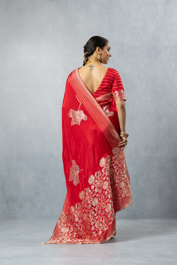 Back view of Vanya Red Saree, featuring the low-cut back of the blouse and the striped, flowing pallu with large motifs.