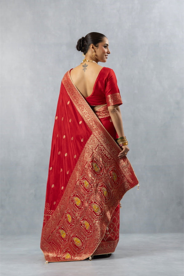 Vanya Red Brocade saree back view, highlighting the low-cut back blouse and the wide, intricately woven gold zari pallu.
