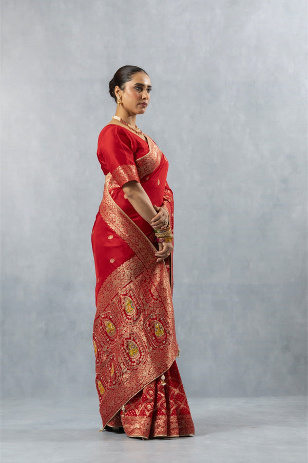 Vanya Red Saree profile view, clearly illustrating the heavy gold brocade pallu draped over the shoulder.