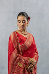 Upper body close-up of Vanya Red Saree, focusing on the heavy zari border, elegant bun, and traditional Kundan jewellery.