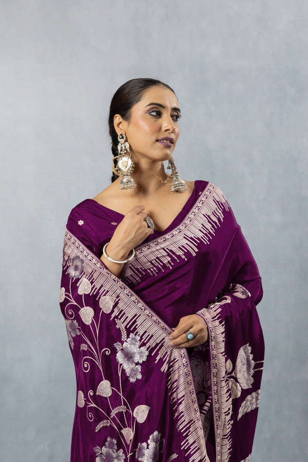 Close-up of the silver zari woven pallu on the Vanya plum purple saree, showcasing the intricate swan and floral design over the model's shoulder.