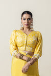 A clear front view of the Vanya Sarees readymade yellow brocade blouse, showing the V-neck, puff sleeves, and mirror work cuffs.