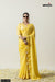 A full front view of the model in Vanya Sarees' unique yellow saree, showcasing the handcrafted bow border and designer blouse.