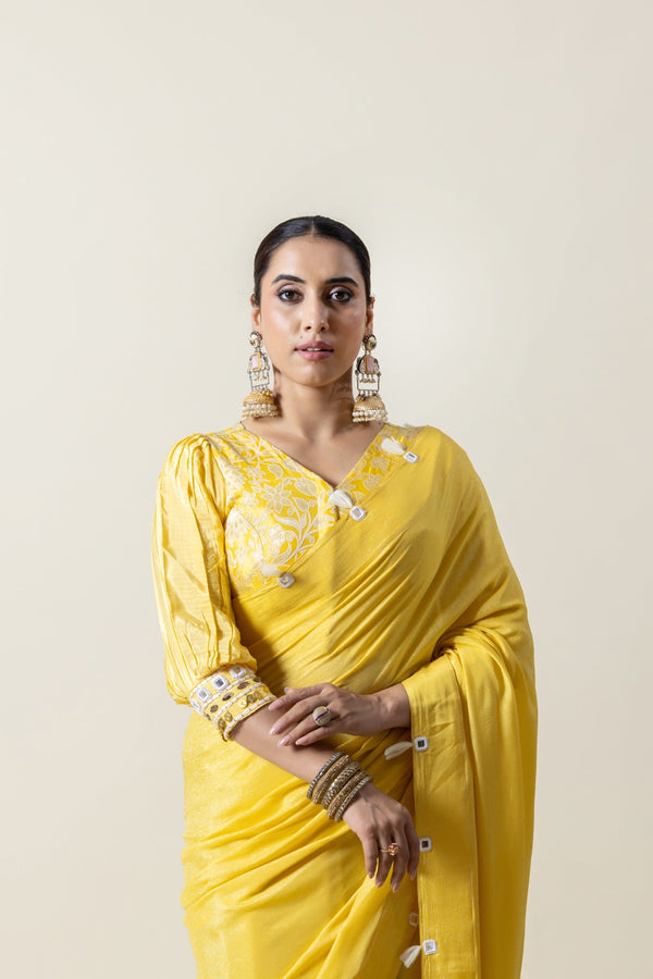 A close-up of the model wearing the Vanya Sarees yellow designer saree, highlighting the brocade and puff sleeve blouse.