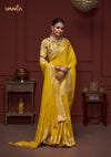 An elegant standing pose of the model showcasing the complete designer look of the Vanya Sarees yellow saree and collared floral blouse.