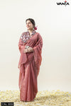 Full-length view of a model smiling in a Vanya designer party wear saree in dusty rose tissue with a contrasting floral blouse.