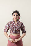 Vanya Model looking away with a joyful expression, showcasing the side profile and drape of the rose pink organza saree and floral blouse.