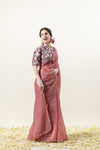 Vanya Close-up of a model wearing a rose tissue organza saree, showing the detailed floral print of the collared blouse and large earrings.