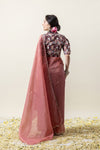 Back view of the model, displaying the drape of the sheer rose tissue saree and the fit of the floral puff-sleeve blouse.