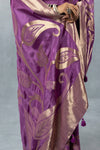 Detailed close-up of the antique gold zari weaving on the Vanya Sarees mauve purple tissue silk saree, showing the artistic leafy and paisley patterns.