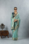 An elegant standing pose of the model in sunglasses, wearing the complete Vanya Sarees aqua blue designer saree ensemble.