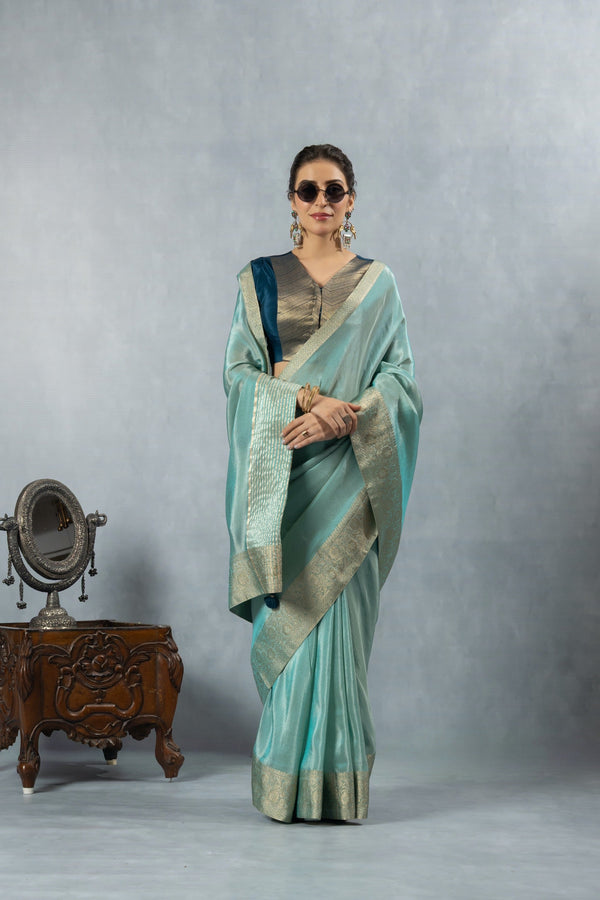 An elegant standing pose of the model in sunglasses, wearing the complete Vanya Sarees aqua blue designer saree ensemble.