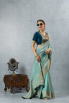 A joyful, smiling pose of the model in the Vanya Sarees aqua blue tissue silk saree, perfect for a festive occasion.