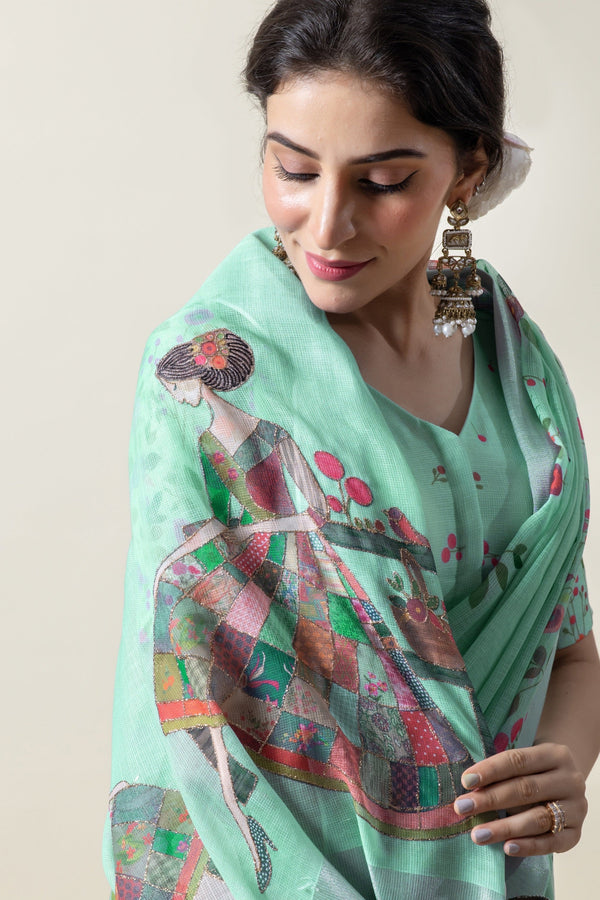 A close-up of the model showcasing the whimsical 'lady in a garden' print on the pallu of the Vanya Sarees linen silk saree.