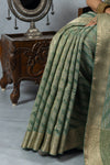 A detailed close-up of the pleats of the Vanya Sarees saree, highlighting the rich texture of the green and gold Leheriya weave.